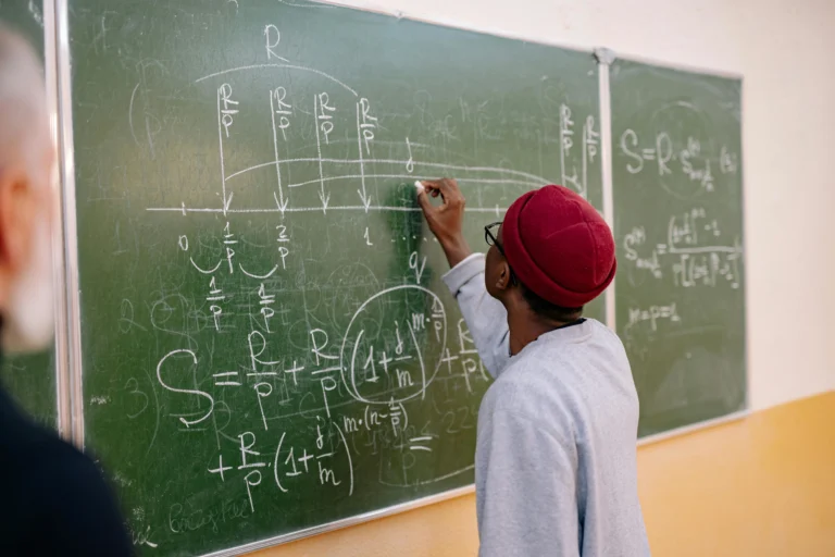 Person Writting on Greenboard